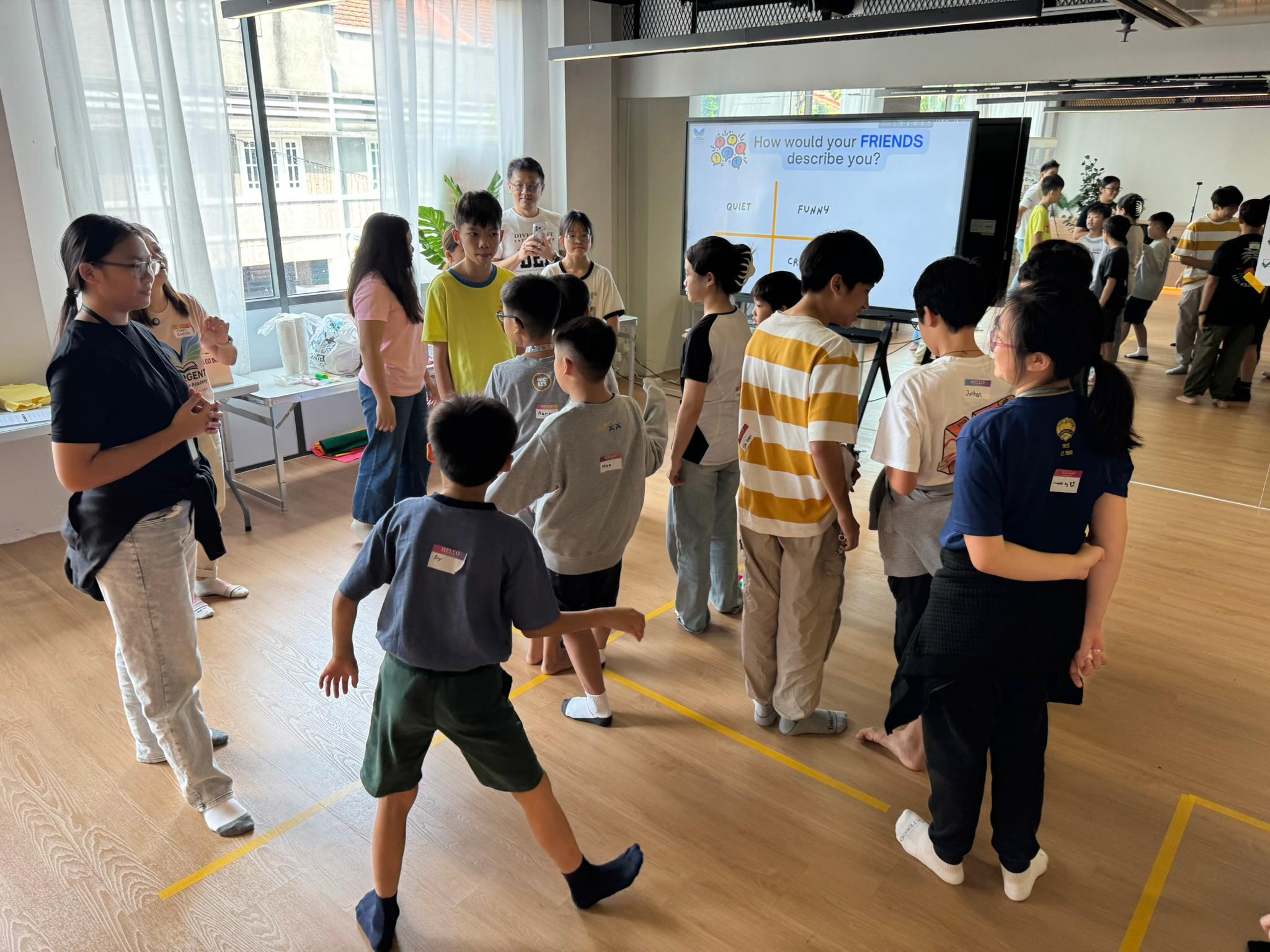 Young participants in a Divergent Entrepreneur Academy workshop, working through a group activity in a bright studio